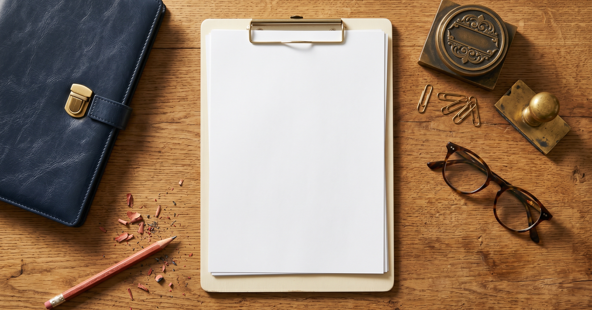 Flat-lay de workspace profissional com prancheta, caneta-tinteiro e óculos sobre mesa de madeira — representação editorial de elaboração de documentos psicológicos